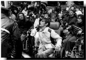Black and white photo of a large group of people protesting. Some are in wheelchairs.