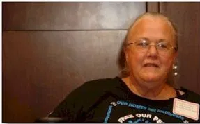A person with eyeglasses and dark shirt with the ADAPT logo.