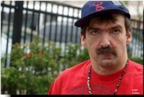 Picture of Larry Biondi A man in a blue cap with the ADAPT logo embroidered in red and a red top looks into the camera.