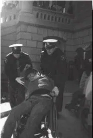 Protestor in a wheelchair getting arrested. Black and white photo of a person in a wheelchair being arrested by two police officers.