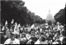 Black and white picture of a large crowd of people outside. The Capitol building is visible in the background.