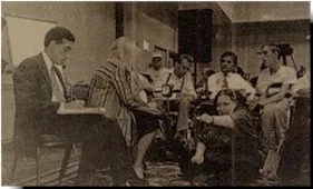 A black and white picture of a group of people, some in wheelchairs and some are not, in what appears to be a meeting.